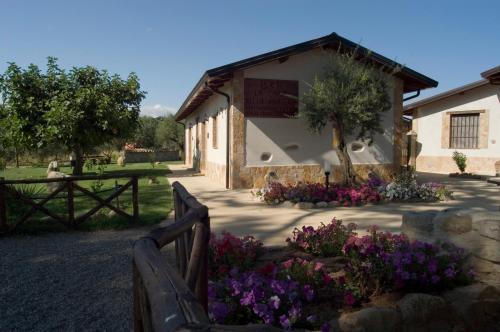 a fence in front of a building with flowers at La Casa nella Prateria in Altomonte