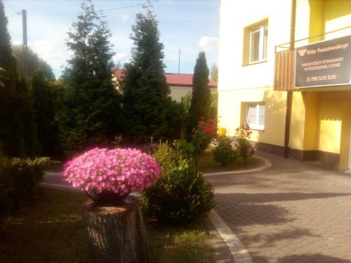 a bunch of pink flowers in front of a building at Willa Poniatowskiego in Grodzisk Mazowiecki