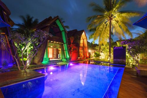 a house with a swimming pool at night at Kies Villas Lombok in Kuta Lombok