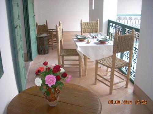 una sala da pranzo con tavolo e vaso di fiori di Dar El Kharaz a Marrakech