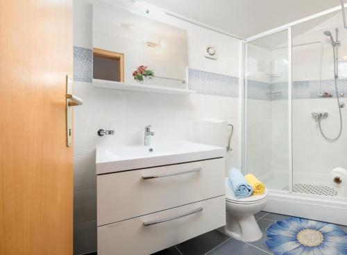 a bathroom with a toilet and a sink and a shower at Apartments Jurić in Podstrana