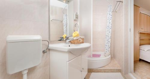 a small bathroom with a sink and a toilet at Apartments Jurić in Podstrana