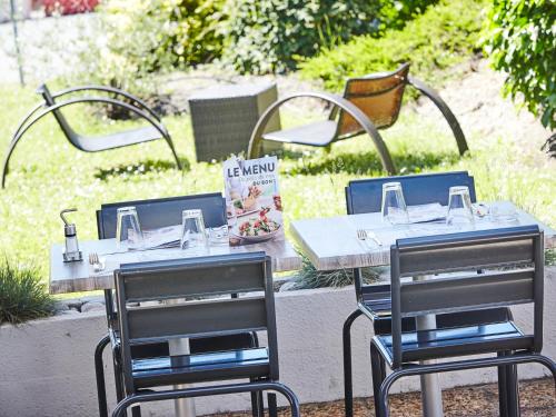 アルティーグ・プレ・ボルドーにあるCampanile Bordeaux Est - Artiguesのテーブル2つ、椅子2脚、テーブル1脚、椅子1脚