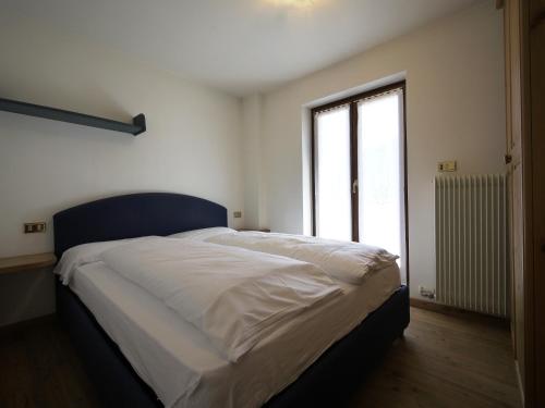 a bedroom with a large bed with a large window at Appartamenti Home Service in Arabba