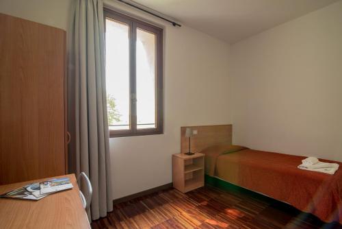 a bedroom with a bed and a window and a table at Hotel Casa a Colori Venezia in Dolo