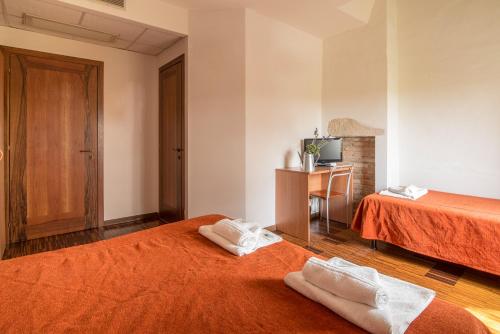a hotel room with two beds with towels on them at Hotel Casa a Colori Venezia in Dolo