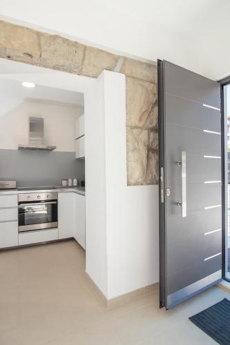 a kitchen with white cabinets and a sliding door at Holiday Home Aspalathos - with free parking, near the beach, a few minutes' walking distance to the UNESCO Palace in Split