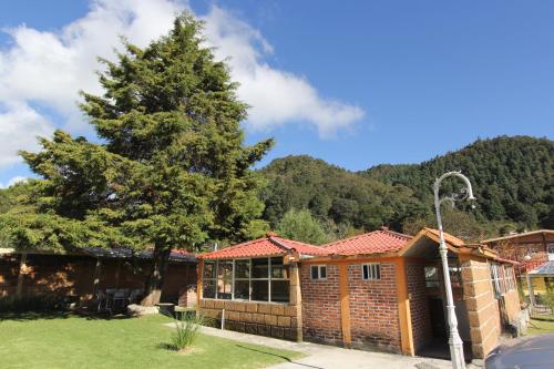 a house with a tree in the yard at Hotel Real de San Antonio in Estanzuela