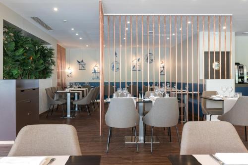 a restaurant with tables and chairs in a room at Hôtel Birdy by Happyculture in Aix-en-Provence