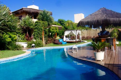 a swimming pool in a yard next to a house at 0031 Boutique Hotel & Restaurant Cumbuco in Cumbuco