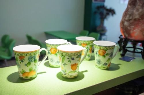 un grupo de tazas sentadas sobre una mesa en Zhizhu Homestay en Tainan