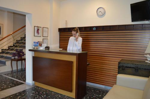 a woman standing at a reception desk in a room at Hotel Strimoniko in Asprovalta