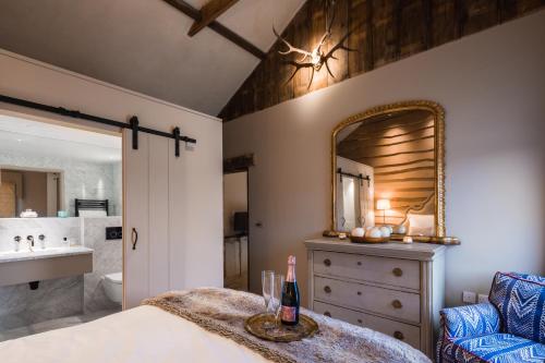 une chambre avec un lit, un lavabo et un miroir dans l'établissement Cambridge Country Cottages, à Cambridge