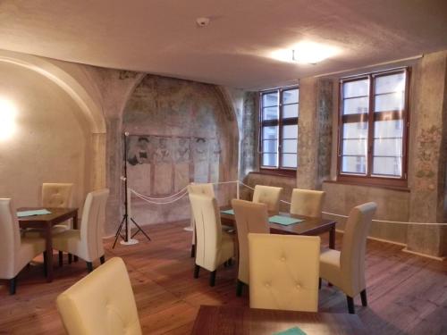 a dining room with tables and chairs and windows at Hotel Schwibbogen Görlitz in Görlitz