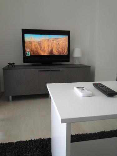a living room with a flat screen tv on a cabinet at Apartments IVI Gevgelija in Gevgelija