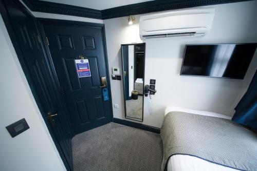 a bedroom with a bed and a mirror and a door at The House of Toby in London
