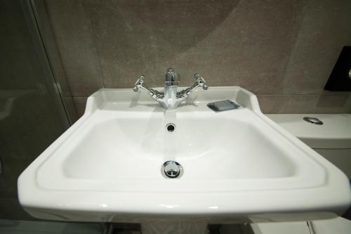 a white sink with a faucet in a bathroom at The House of Toby in London