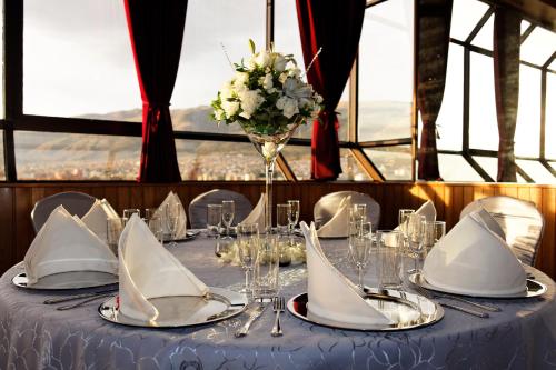 a table with white napkins and a vase of flowers at Hotel Diplomat in Cochabamba
