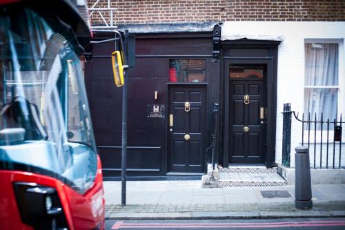 a building with black doors on a city street at The House of Toby in London