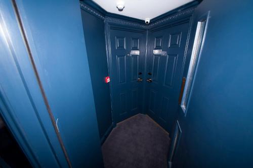 a hallway with blue walls and a blue door at The House of Toby in London
