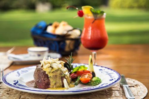 a plate of food on a table with a drink at Las Mañanitas in Cuernavaca
