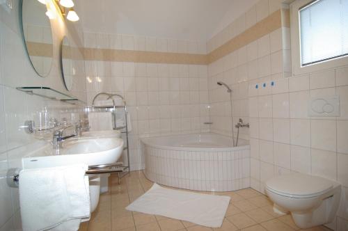 a bathroom with a tub and a toilet and a sink at Chalet Tirolerland in Mayrhofen