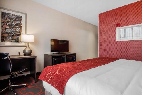 a hotel room with a bed and a television at Comfort Inn & Suites near Stadium in Bronx