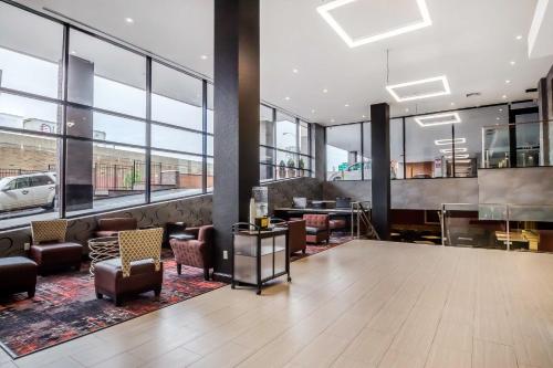 a lobby with chairs and tables and large windows at Comfort Inn & Suites near Stadium in Bronx