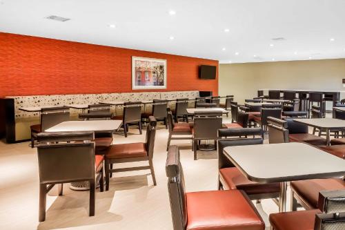 an empty dining room with tables and chairs at Comfort Inn & Suites near Stadium in Bronx