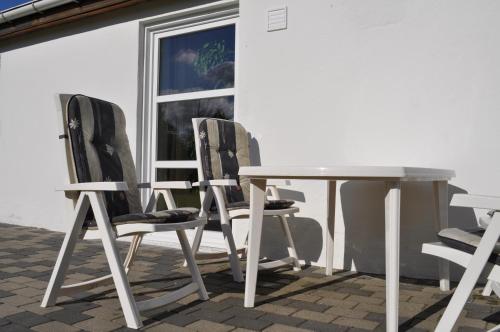 three chairs and a table on a patio at Koebenhovedskov Bed & Breakfast in Rødding