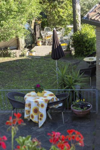 a table and chairs with an umbrella in a yard at B&B Il Giardino in Tavullia