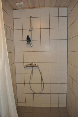 a shower with a hose in a white tiled bathroom at Koebenhovedskov Bed & Breakfast in Rødding