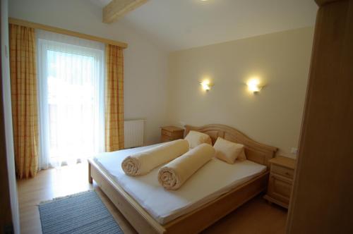 a bedroom with a bed with two pillows and a window at Chalet Tirolerland in Mayrhofen