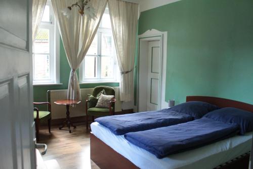 a bedroom with a bed with blue sheets and green walls at Gästehaus Tobringen 20 in Tobringen