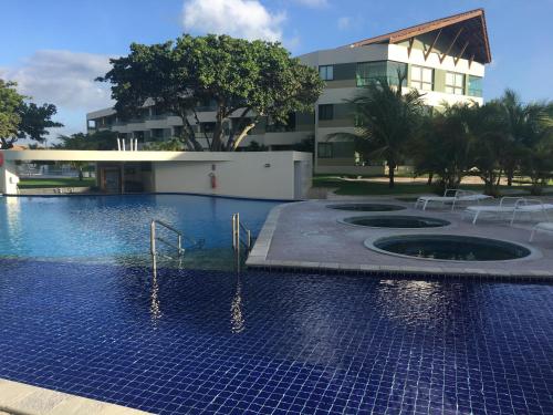 uma piscina em frente a um edifício em Carneiros Beach Resort Flat em Tamandaré