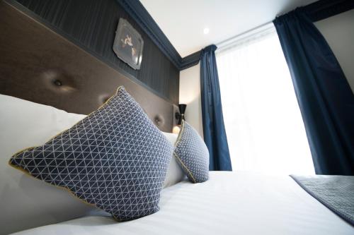 a bedroom with a bed with two pillows and a window at The House of Toby in London