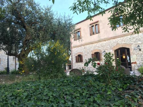 an old stone building with trees in front of it at Agriturismo Sant'Agata in Piana degli Albanesi