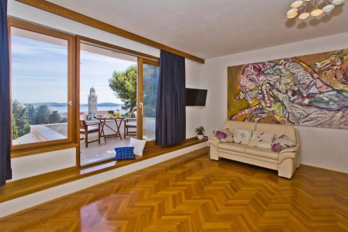 a living room with a couch and a large painting on the wall at Castle Štambuk in Hvar