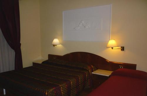 a hotel room with a bed and two lamps at Hotel Benessere Villa Fiorita in Colfiorito