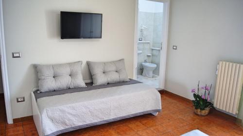 a bedroom with a bed with a flat screen tv on the wall at Le Stanze di Lucia vicino Ospedale Cardinale Panico a Tricase in Tricase