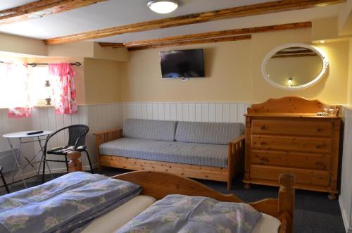 ein Schlafzimmer mit einem Bett, einem Sofa und einem Spiegel in der Unterkunft Ferie På Toppen in Skagen
