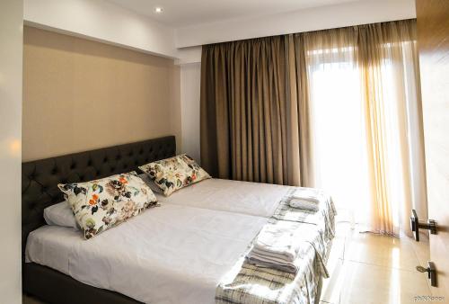 a bedroom with a bed with pillows and a window at Island Dreams Rooms & Suites in Rhodes Town