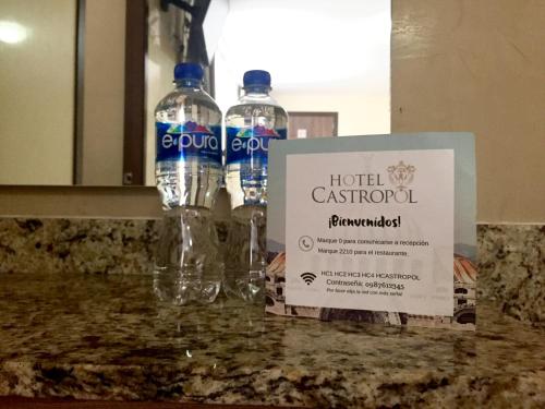 two bottles of water sitting on a counter with a sign at Hotel Castropol in Mexico City