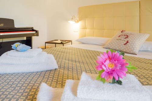 a bedroom with a bed with towels and a piano at il Giardino delle Zie in Tricase