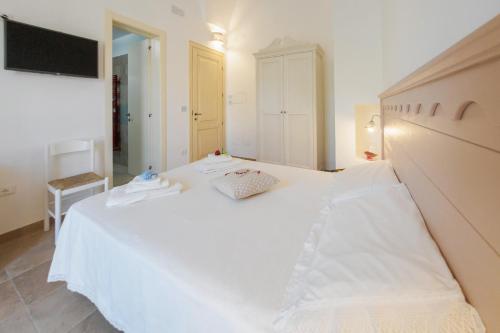 a large white bed in a room with a television at il Giardino delle Zie in Tricase