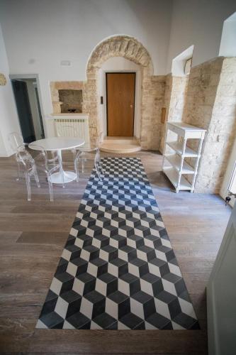 a room with a checkered floor and a table and chairs at Palazzo Siena De Facendis in Bitonto
