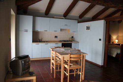 a kitchen with white cabinets and a table and chairs at Cà Veja in Montà