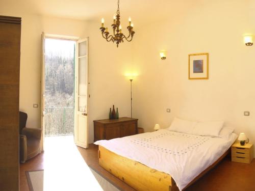 a bedroom with a bed and a chandelier at A House In Tuscany in Bagnone