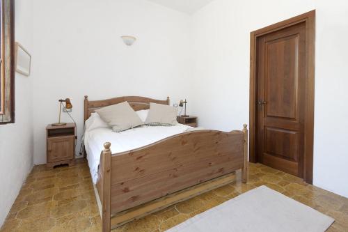 a bedroom with a wooden bed with two pillows on it at A House In Tuscany in Bagnone