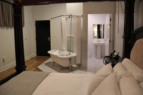 a bathroom with a bath tub and a sink at The Inn on the River in Donaldsonville